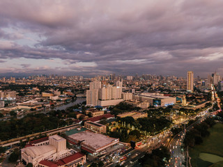 Aerial drone shot of the lightened up Skyline of Binondo District in Metro Manila while sunset
