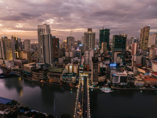 Fototapeta na wymiar Aerial drone shot of the lightened up Skyline of Binondo District in Metro Manila while sunset 