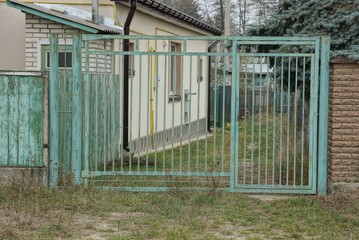 old metal gate made of iron bars on a rural street