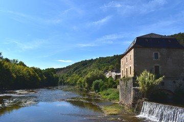 Fototapeta na wymiar Picture of a beautiful river lined with stone houses in south of France. Countryside vacation background.