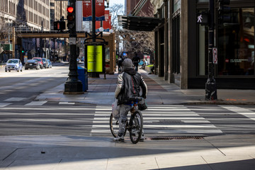 Chicago,IL/USA-April 18th 2020: People are walking the streets of downtown Chicago wearing masks...