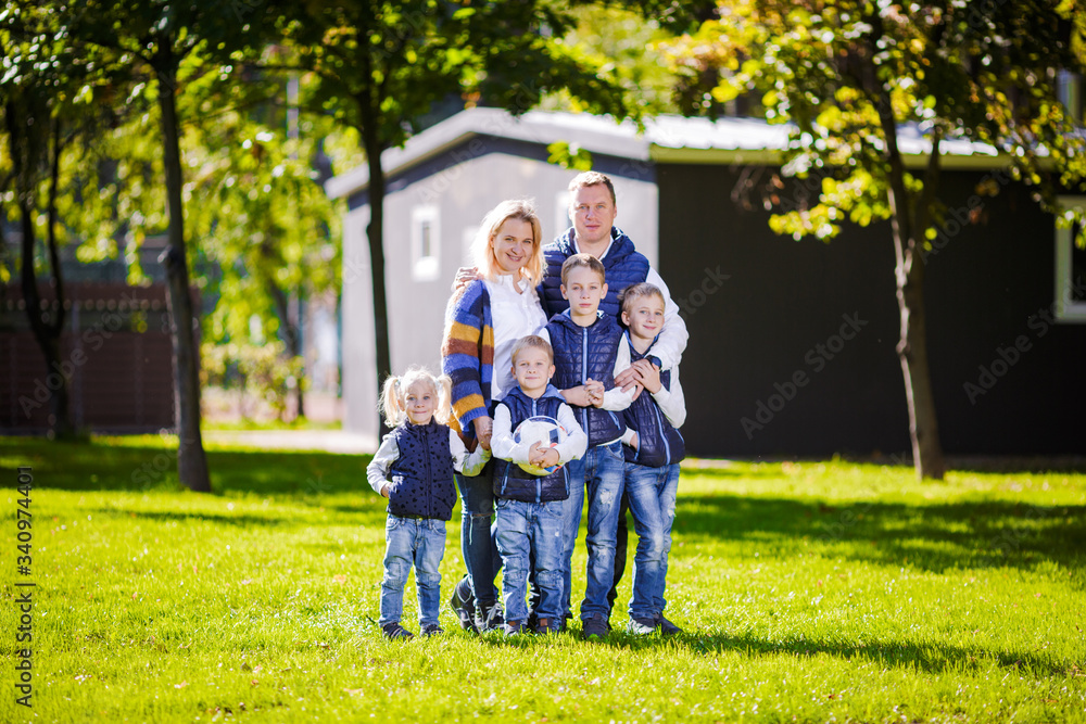 Wall mural happy family outdoors. happy caucasian family standing outside their house and hugging. family with 