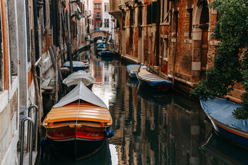 Fototapeta na wymiar Parked boats in the narrow canal of Venice | VENICE, ITALY - 16 SEPTEMBER 2018. 