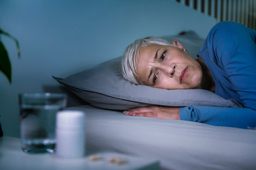 Insomnia and sleeping pills that do not work. Mature woman with sleeping problems awake in the middle of the night