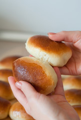 hands hold homemade patties pirozhki over round wooden board 