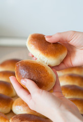 hands hold homemade patties pirozhki over round wooden board 