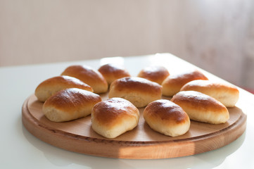 homemade patties pirozhki on round wooden board