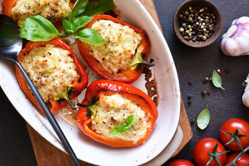 Baked bell pepper with meat and rice on a concrete dark background.