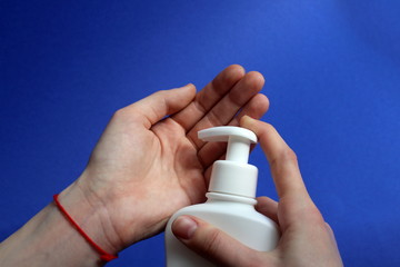 Female hands squeeze disinfectant liquid from a bottle