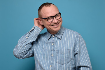 Mature man looking embarrassed feeling shy or flattered with compliment