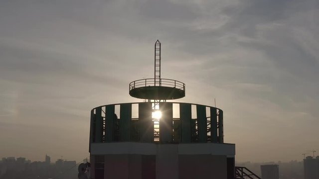 silhouette of a roof spire, lightning rod in a skyscraper. against the backdrop of sunset and evening city center