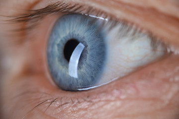 Male eye blu color super macro closeup shot. Laser vision correction and cataract treatment concept