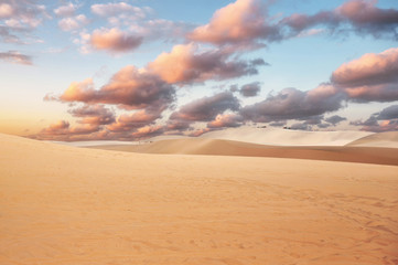 Fototapeta na wymiar Sand dune with colorful cloud in sky on desert