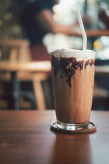 Iced mocha coffee with chocolate cream poured into glass it showing the texture