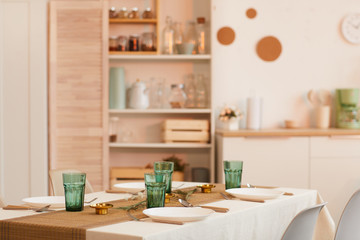 Warm toned image of cozy kitchen interior with served table in foreground, copy space