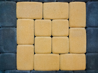 Paving tiles are lined with a pattern. Decorative street background. Sidewalk. Modern road surface.