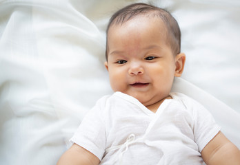 Cute newborn baby girl in white blanket on nursery bed. Adorable new born child, little boy eyes look people Family, new childhood, infant soft skin portrait concept. Jaundice syndrome life hospital.