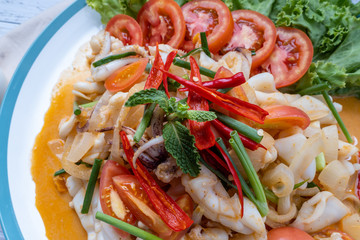 Stir-fried squid with salted egg yolk, onion, spring onion and Chili pepper on white plate. Food concept. Thailand seafood cuisine. thai food