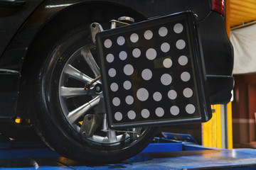 collapse-convergence. auto mechanic sets the car for diagnostics and configuration. Car Wheels alignment equipment on stand in a repair station. Car on stand with sensors wheels for alignment camber.