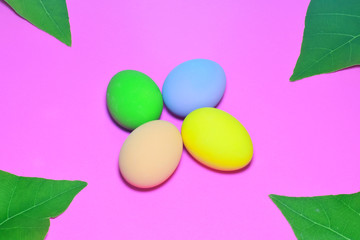 Easter eggs and natural leaves arranged as a separate backdrop on the pink background.