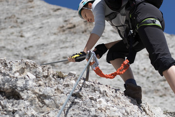 Climbing along a steel line on the via ferrata route in the dolomites