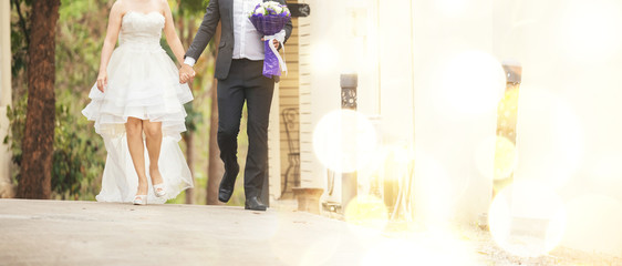 Couple together walking and hold hand before wedding day. lady in wedding dress walk with her husband, out door pre wedding activity, marriage and wedding concept