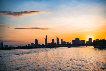 River city view landscape at twilight sunset. Boat on river with tranquil water. Hochiminh city Saigon vietnam cityscape building with Bitexco tower
