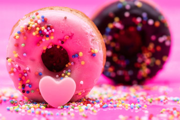 Donuts on pink background. donut with heart and candy. Sweet donuts. Sweet background. holiday, fun, love concept
