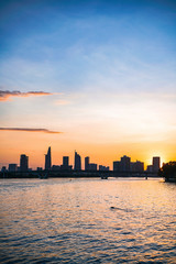 River city view landscape at twilight sunset. Boat on river with tranquil water. Hochiminh city Saigon vietnam cityscape building with Bitexco tower