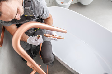 Handyman Attaches Faucet Kit To Complete Tub Installation.