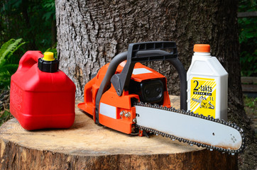 chainsaw with canister of gasoline and motor oil