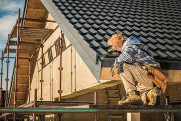Male Roof Contractor Reviews Project Progress.