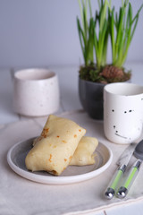 Baked large pancakes with filling, on the table with a light napkin under the plate