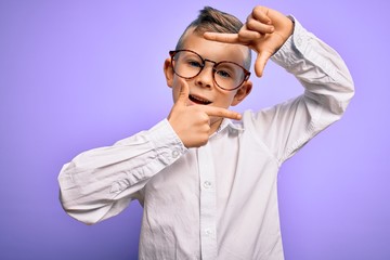 Young little caucasian kid with blue eyes wearing glasses and white shirt over purple background smiling making frame with hands and fingers with happy face. Creativity and photography concept.