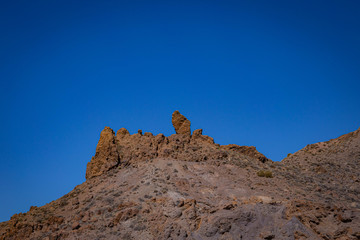 Volcanic rocks in the hills of Tenerife with clear blue skies