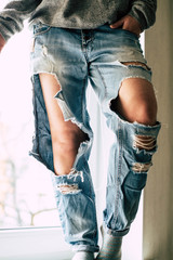 Girl and torn jeans. Modern youth