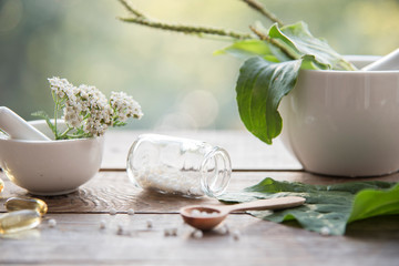 homeopathic granules, medicinal herbs on a natural wooden table on a natural background. alternative medicine and homeopathy - obrazy, fototapety, plakaty