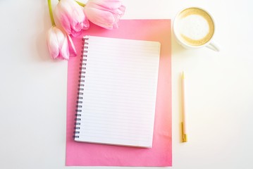Empty notebook spring pink tulips flowers, cup of coffee. Mockup notepad on pink background. Still life. Spring romantic mood. Colorful light. Feminine desctop. Top view. Copy space