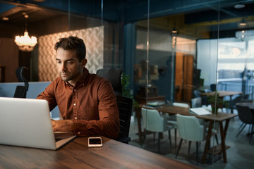 Businessman working on his laptop after hours in an office