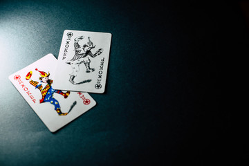 Joker card on black background under light