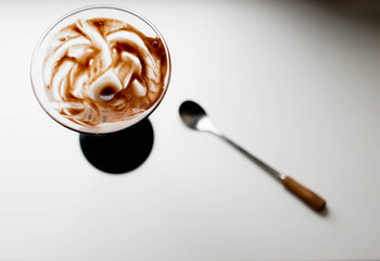 Glass of chocolate dessert on a white windowsill
