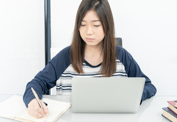 Young female student  sitting in living room and learning online