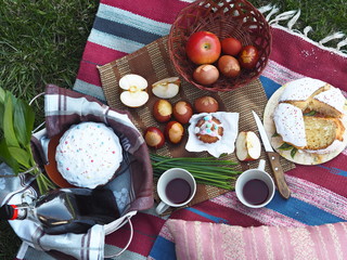 Spring picnic with Easter cakes, homemade wine and eggs.Easter feeding on the grass on the lawn in the yard.