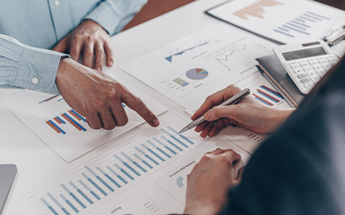 Businessman and financial team are analyzing the results of operations and calculating the...