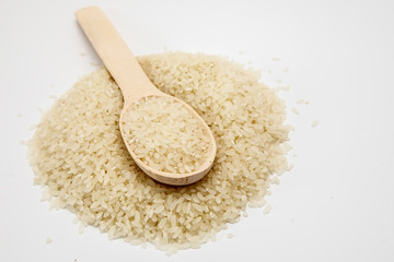 Grits rice in a wooden spoon, background. Rice background