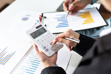 Meeting a team of businessmen, Executives and accountants meeting about the company's revenue graph in the office with laptops and calculators, Finance concept.
