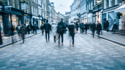 Motion blurred people shoppers on busy street