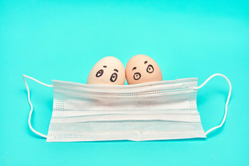 chicken eggs under protective medical mask. concept of health virus and social distance. aqua background