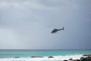 Fototapeta na wymiar helicopter in flight over the beach