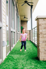 Toddler Girl Running on Balcony